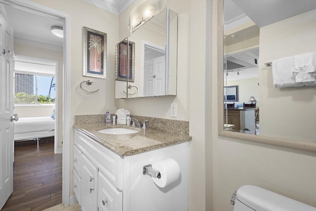 bathroom with ornamental molding, hardwood / wood-style floors, vanity, and toilet