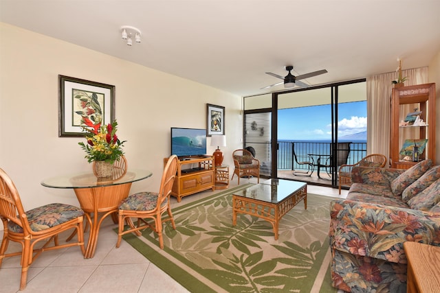 tiled living room featuring ceiling fan and expansive windows