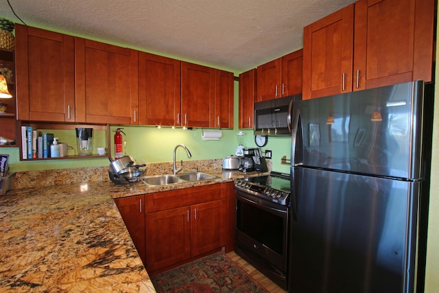 kitchen featuring light stone countertops, a textured ceiling, sink, fridge, and electric range