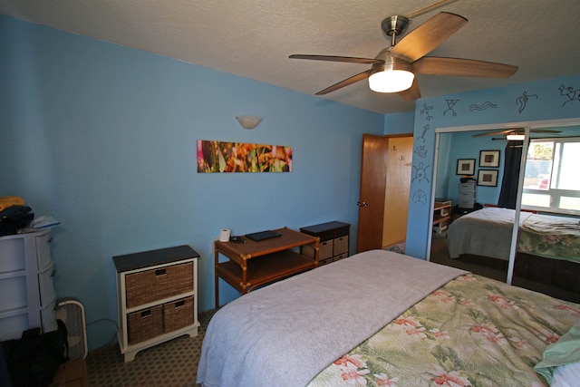 carpeted bedroom with a textured ceiling, ceiling fan, and a closet