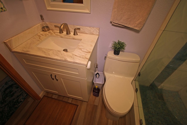 bathroom featuring toilet, vanity, and a shower