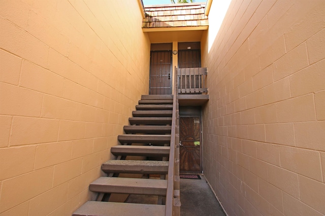 stairway featuring a skylight and a high ceiling