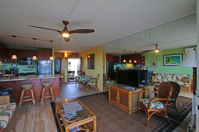 living room featuring ceiling fan and sink