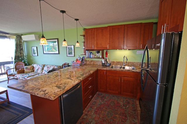 kitchen featuring kitchen peninsula, black fridge, dishwasher, an AC wall unit, and sink