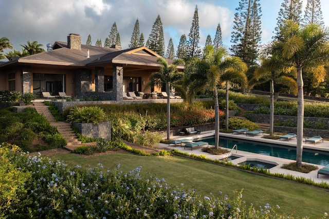 back of house featuring a pool with hot tub, a patio area, and a yard