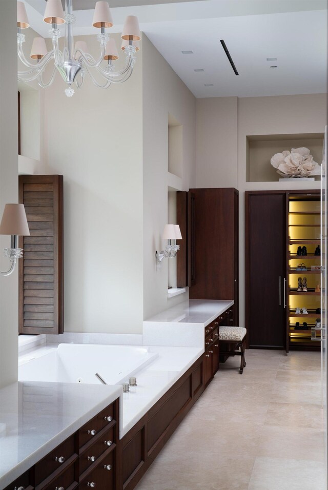 bathroom with a tub to relax in and a chandelier