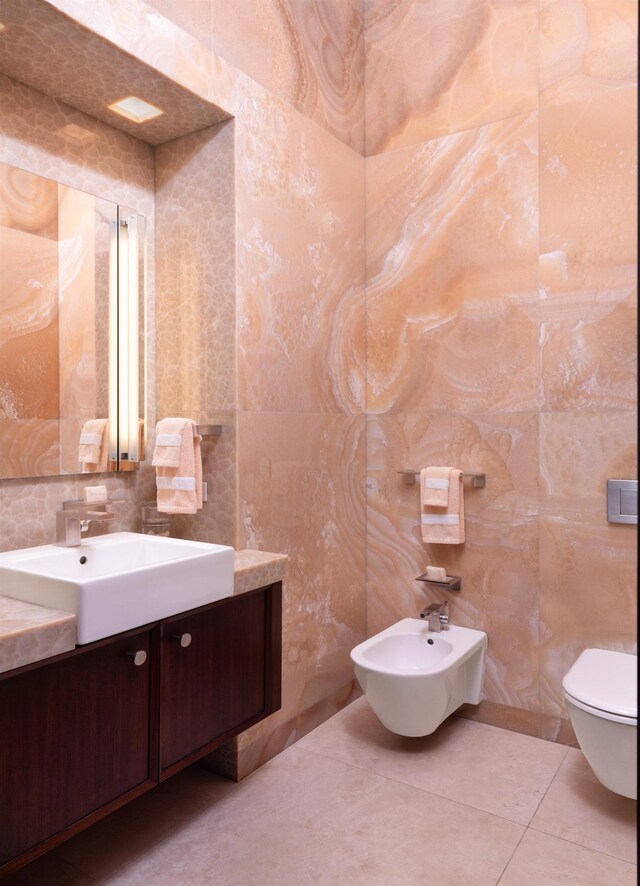 bathroom featuring toilet, vanity, a bidet, and tile patterned floors