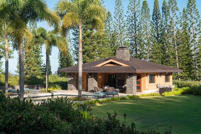 back of property featuring a lawn, cooling unit, an outdoor living space with a fireplace, and a patio