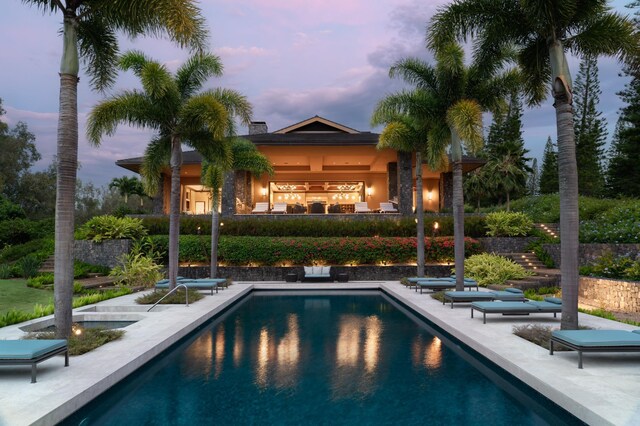 pool at dusk featuring a patio area