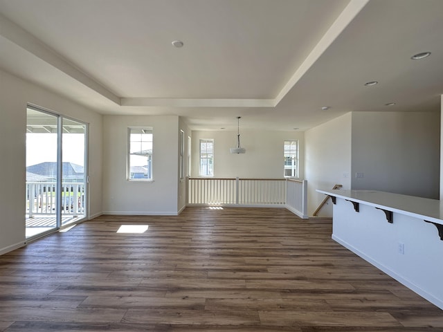 spare room featuring a mountain view, dark hardwood / wood-style flooring, plenty of natural light, and a tray ceiling