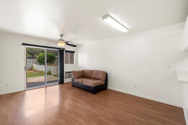 80 Waiaka Ln Unit 37-103, Wailuku, HI 96793 - living area featuring wood finished floors, a ceiling fan, and a wall mounted air conditioner