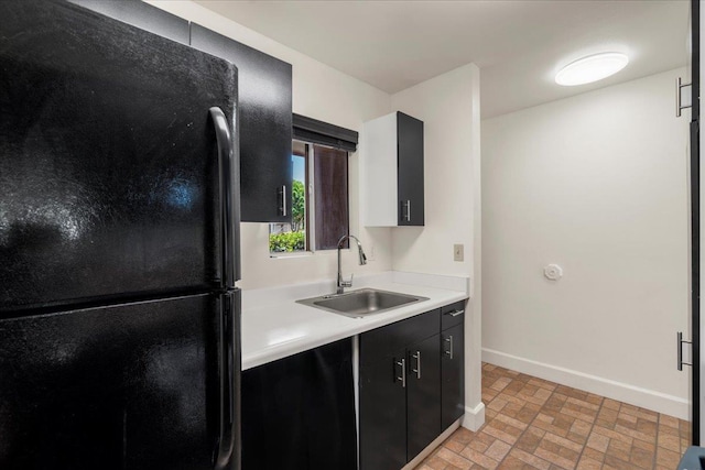 80 Waiaka Ln Unit 37-103, Wailuku, HI 96793 - kitchen featuring freestanding refrigerator, dark cabinetry, light countertops, and brick patterned flooring