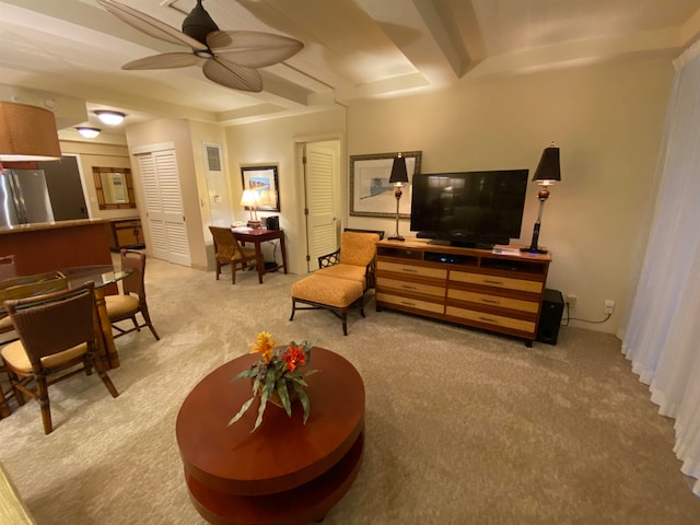 carpeted living room featuring beamed ceiling and ceiling fan