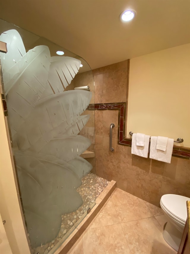 bathroom with a shower, tile walls, toilet, and tile floors