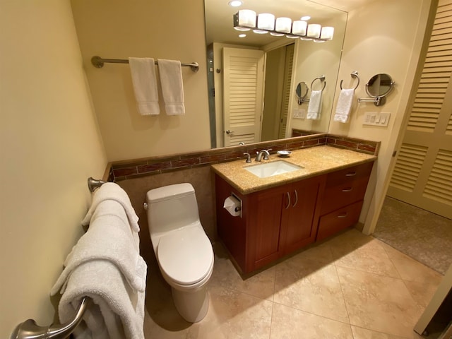 bathroom featuring tile floors, large vanity, and toilet