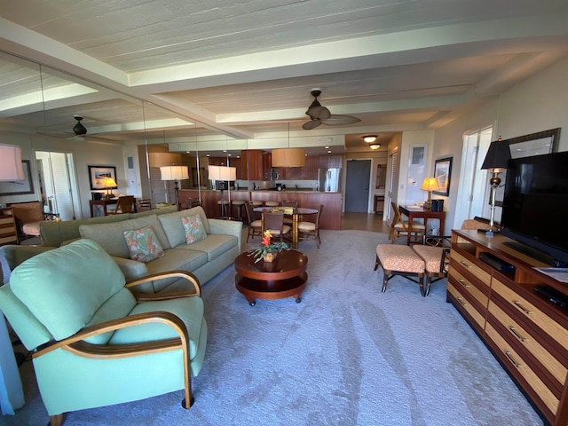 living room with beamed ceiling, carpet, and ceiling fan