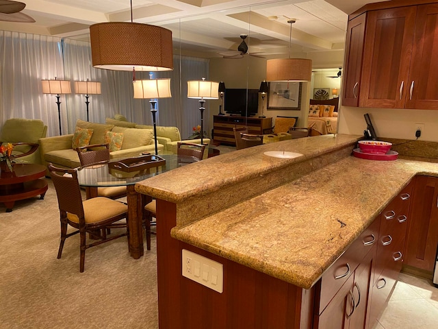 kitchen with light stone countertops, light tile flooring, ceiling fan, and hanging light fixtures