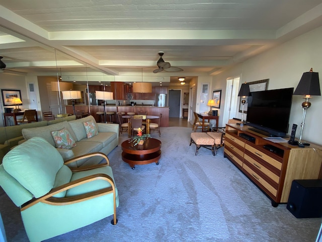 carpeted living room featuring beamed ceiling and ceiling fan