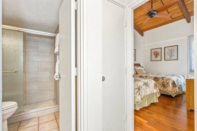 bathroom with ceiling fan, toilet, ensuite bathroom, and a stall shower