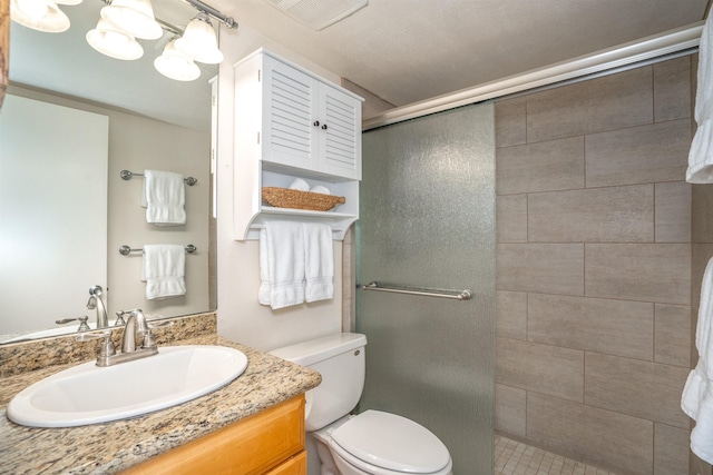 full bathroom with a shower stall, toilet, vanity, and visible vents