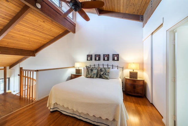 bedroom with lofted ceiling with beams, wooden ceiling, wood finished floors, and multiple windows