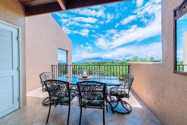 balcony with outdoor dining space and a mountain view