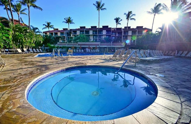 community pool with a patio area and a community hot tub