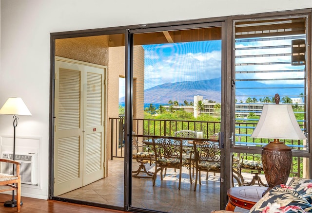 doorway featuring wood finished floors, a wall mounted air conditioner, and a mountain view