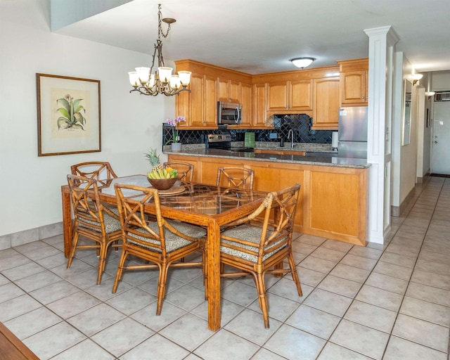 kitchen featuring tasteful backsplash, appliances with stainless steel finishes, light tile patterned floors, and a sink