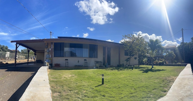 view of front of house featuring a carport and a front lawn