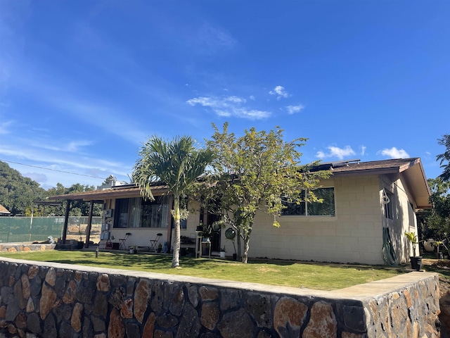 view of front facade with a front yard and solar panels