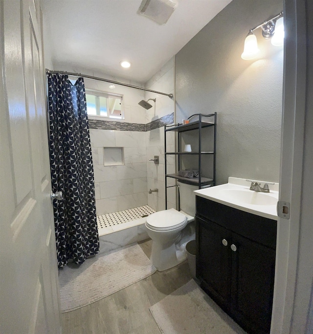 bathroom with a shower with shower curtain, wood-type flooring, vanity, and toilet