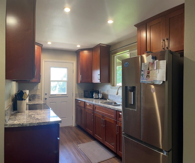 kitchen featuring stainless steel fridge, sink, light stone counters, and dark hardwood / wood-style floors