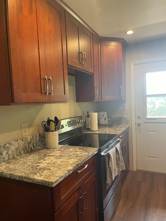 kitchen featuring electric range, light stone counters, and dark hardwood / wood-style floors