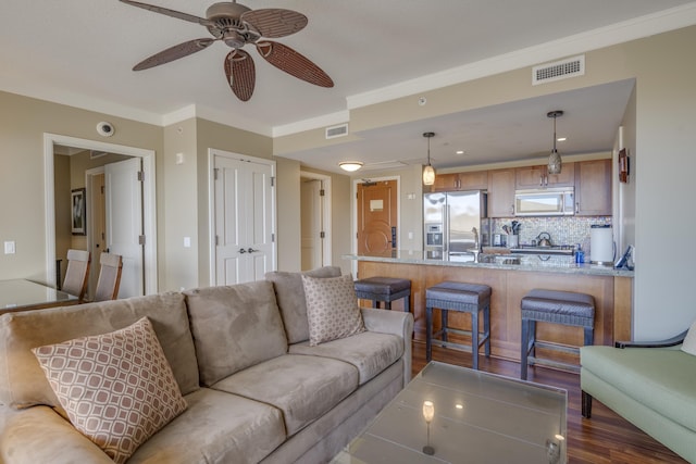 living room featuring ceiling fan and ornamental molding