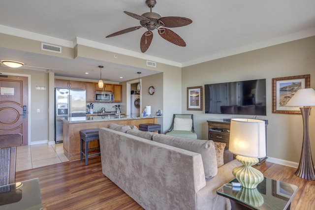 living room with hardwood / wood-style floors, ornamental molding, and washer / clothes dryer