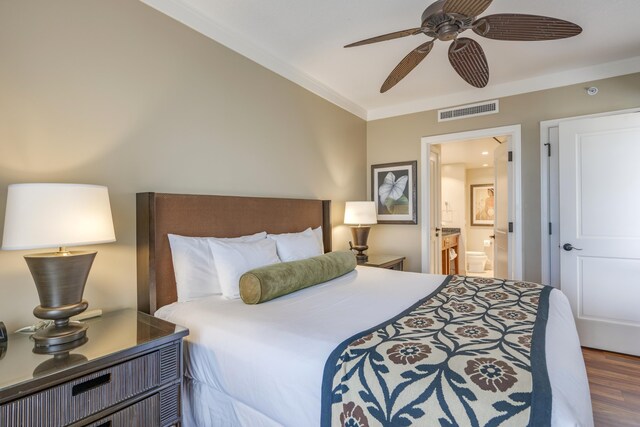 bedroom with dark wood-type flooring, ensuite bath, ceiling fan, and ornamental molding