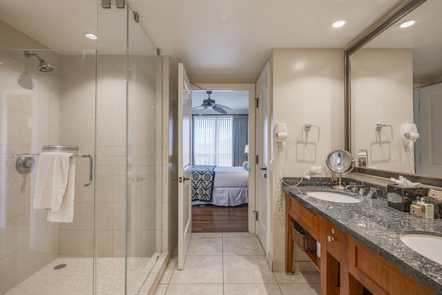 bathroom featuring a shower with door, vanity, ceiling fan, and tile patterned flooring