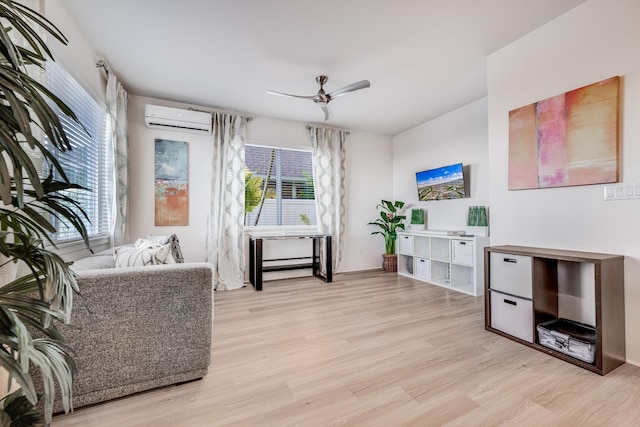 sitting room featuring an AC wall unit, ceiling fan, and light wood-type flooring