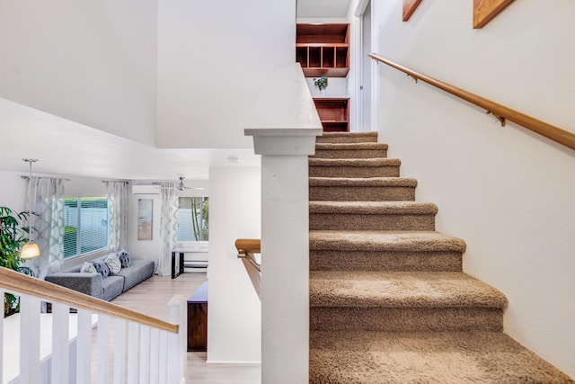 stairway featuring wood-type flooring and a high ceiling