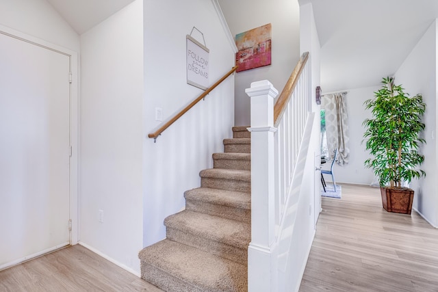 stairs with hardwood / wood-style flooring and vaulted ceiling