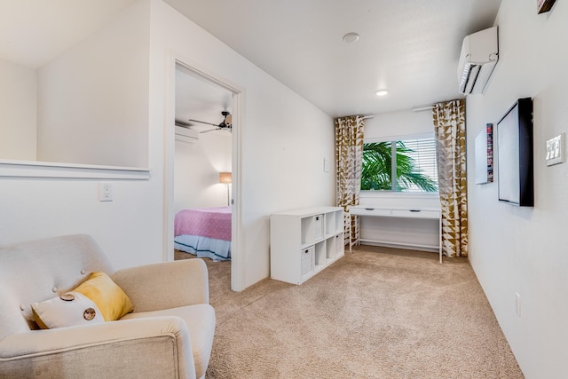 sitting room featuring a wall mounted air conditioner, light colored carpet, and ceiling fan