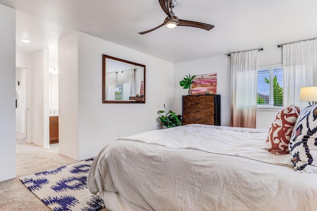 bedroom featuring ceiling fan, connected bathroom, and light carpet