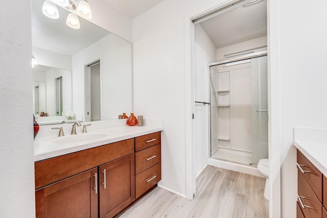 bathroom with walk in shower, wood-type flooring, toilet, and vanity