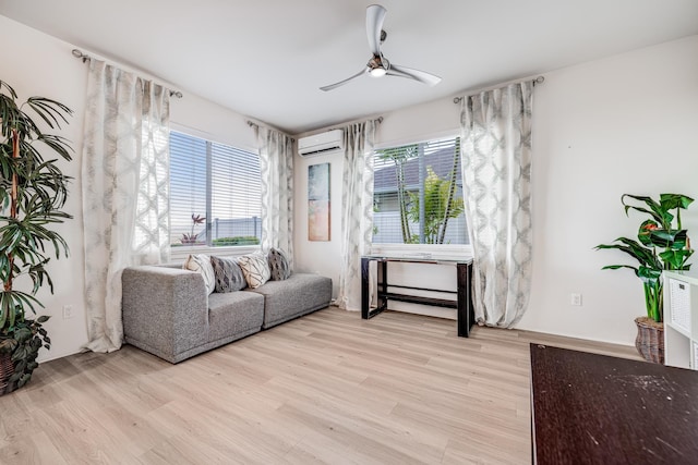 living room with a healthy amount of sunlight, light hardwood / wood-style floors, and a wall unit AC