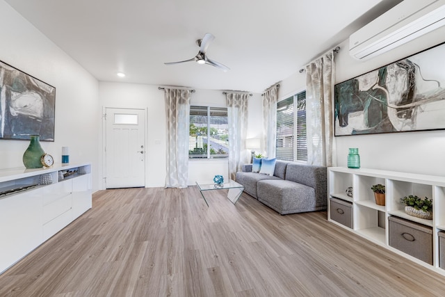 sitting room featuring ceiling fan, light hardwood / wood-style floors, and a wall mounted AC