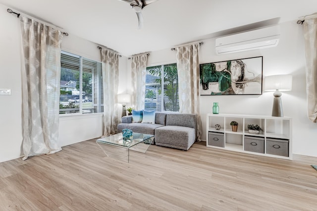 sitting room with an AC wall unit and light wood-type flooring