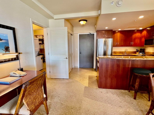 kitchen with sink, stainless steel fridge, light carpet, and kitchen peninsula