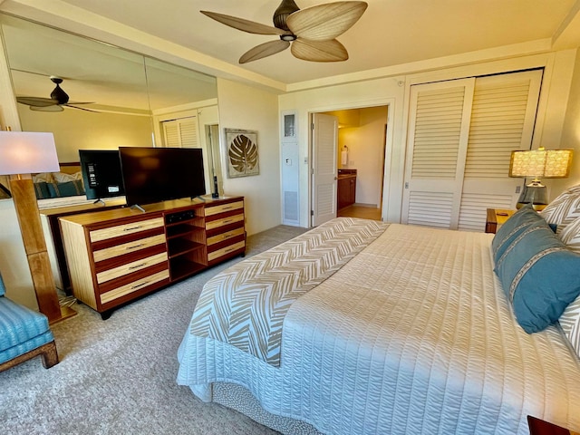 carpeted bedroom with multiple closets and ceiling fan