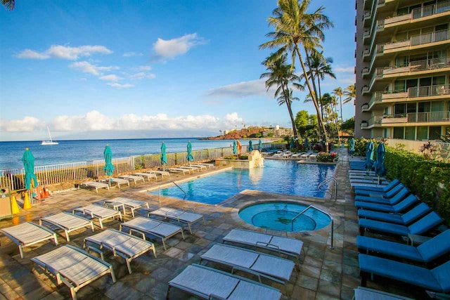 view of swimming pool with a community hot tub, a patio area, and a water view